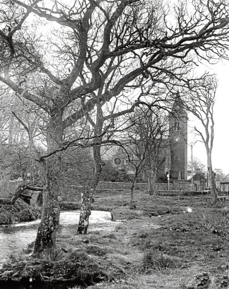 1955: A view of the church of Deer with the River Ugie winding through the trees.