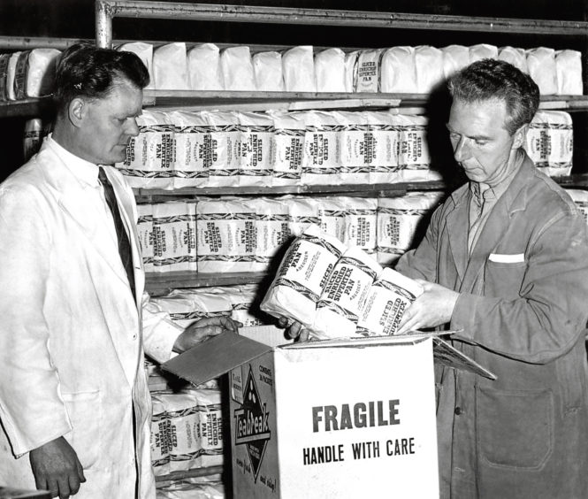 1961: J Hopkins, left, and P Gray, Northern Co-op, pack bread to be sent to Russia.