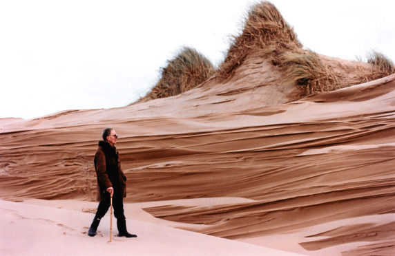 1997: Paul Miller takes a walk past dunes that have been eroded by the wind.