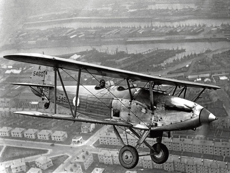 1930s: Overhead Torry with Aberdeen Harbour in the background, an RAF Hawker Hind poses for an in-flight study while on a sortie from Dyce.