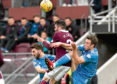 Aberdeen's Andrew Considine competes with Hearts' Michael Smith and Graeme Shinnie.