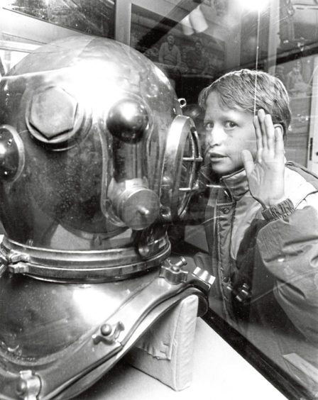 1987: Looking longingly at this magnificent diving helmet is visitor James Anderson
