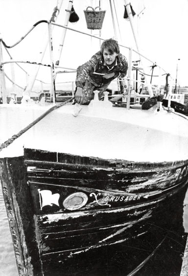 1985: Boat painter David Wielewski at work on the Crusader at Buckie Harbour