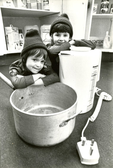 1989: Kelly Sutherland and Gillian Dingwall rest by a kettle and pan demonstrating a child’s eye view of dangers in the kitchen