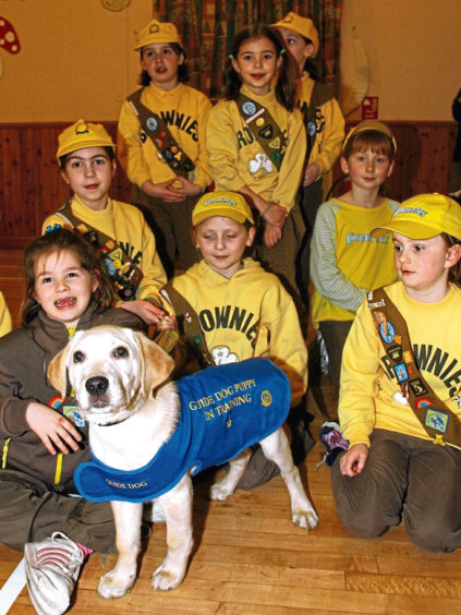 2004: The 1st Kintore Brownies met 12-week-old trainee guide dog Luke after raising money for the Guide Dogs for the Blind Association