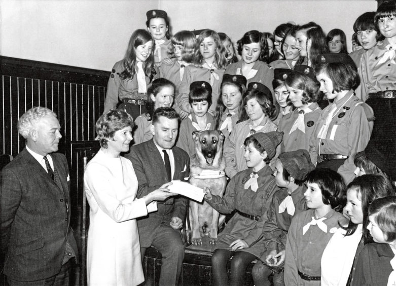 1970: Brownie Janet Stewart presents a cheque to Mr Alex Duguid of Guide Dogs for the Blind at Aberdeen’s Beechgrove Church