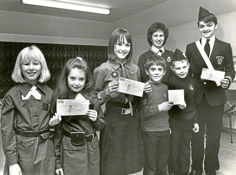 1987: Brownies Louisa Brown and Anna McGovan; Guide Isla Morrison and Boys’ Brigade members Cameron Sharp, Andrew Harper and Keith Young were giving cheques to charity