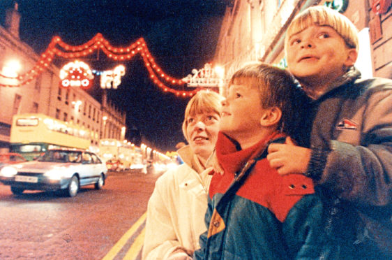 1990: Liz Grant and her sons Malcolm, 4, and Andrew, 6, admire the Christmas lights