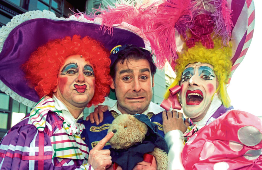 1996: The ugly sisters – Richard Pocock, left, and William Elliot – get their paws on Buttons, played by Andy Gray, in Cinderella