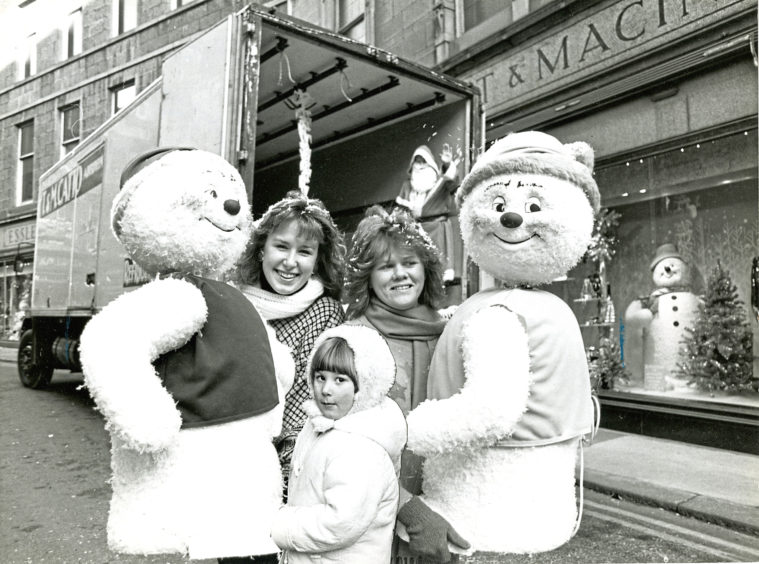 1987: Window dressers Denise Sproston, left, and Karen Presley were on hand to unload mechanical snowmen characters for the Esslemont and Macintosh Christmas display, and to introduce them to Dana Barclay, 4