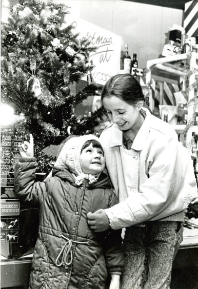1987: Admiring a festive shop window display are Sarah Ewan, 4, and Angela Glennie, 10