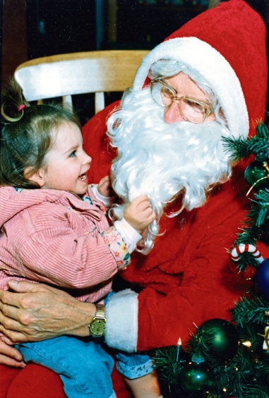 1992: Nikki Paterson, 2, checks all is present and correct with Santa in Debenhams