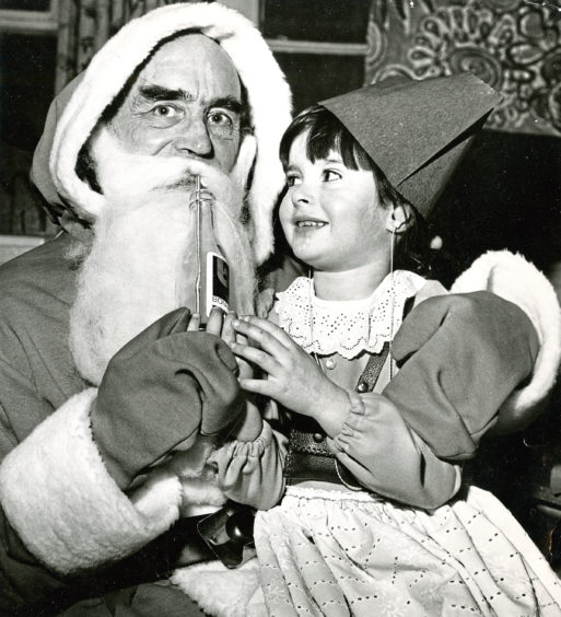 1978: Louise McLeman offers Santa a lemonade as he takes a welcome break from handing out presents to youngsters from Aberdeen School For the Deaf