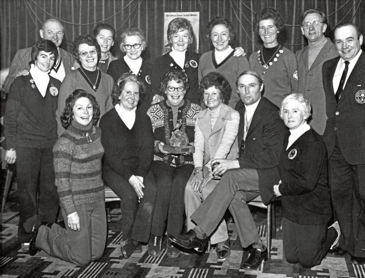 1975: Margaret Service holds the Grouse Whisky Challenge Trophy with the rest of the winning team seated beside her, surrounded by the qualifiers for the final stages