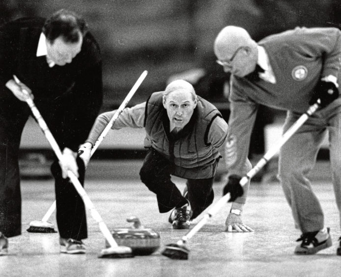 1989: Aberdeen skip Sandy Shand pays close attention to the weight of his stone as his teammates wait for the call to begin sweeping during the RCC rink championship