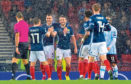 James Forrest, Mikey Devlin and goalscorer John McGinn are pictured celebrating making it 3-0 during the qualifier between Scotland and San Marino