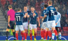 James Forrest, Mikey Devlin and goalscorer John McGinn are pictured celebrating making it 3-0 during the qualifier between Scotland and San Marino