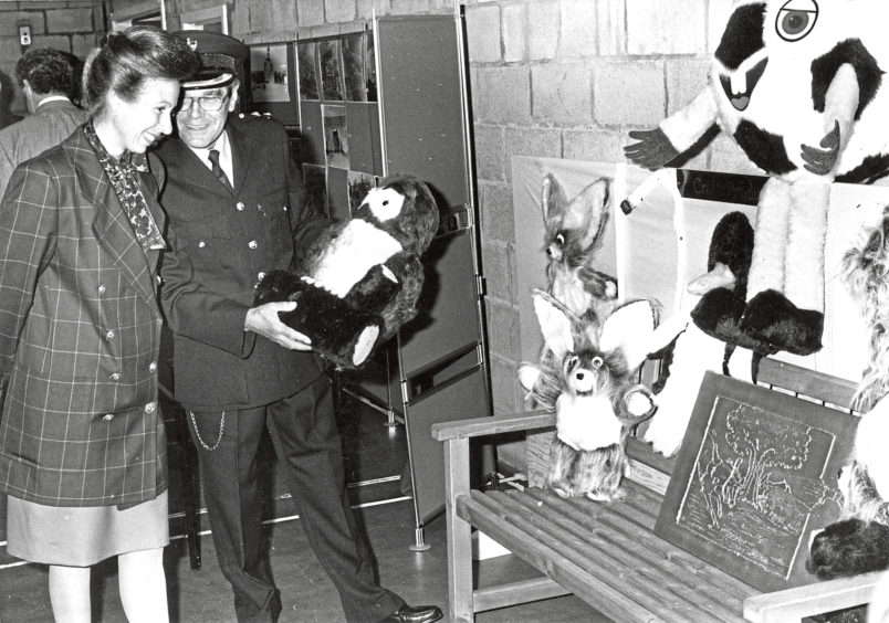 Princess Anne at Peterhead Prison with soft toys and art by prisoners