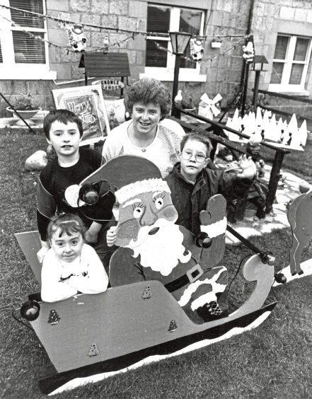 1989: Eight-year-old Craig Wiseman, right, gets ready for the big switch-on in Leonard and Gloria Mackay’s front garden in School Road, Aberdeen. Gloria’s children, John, 9, and Kelly, 5, enjoy a sleigh ride in the display