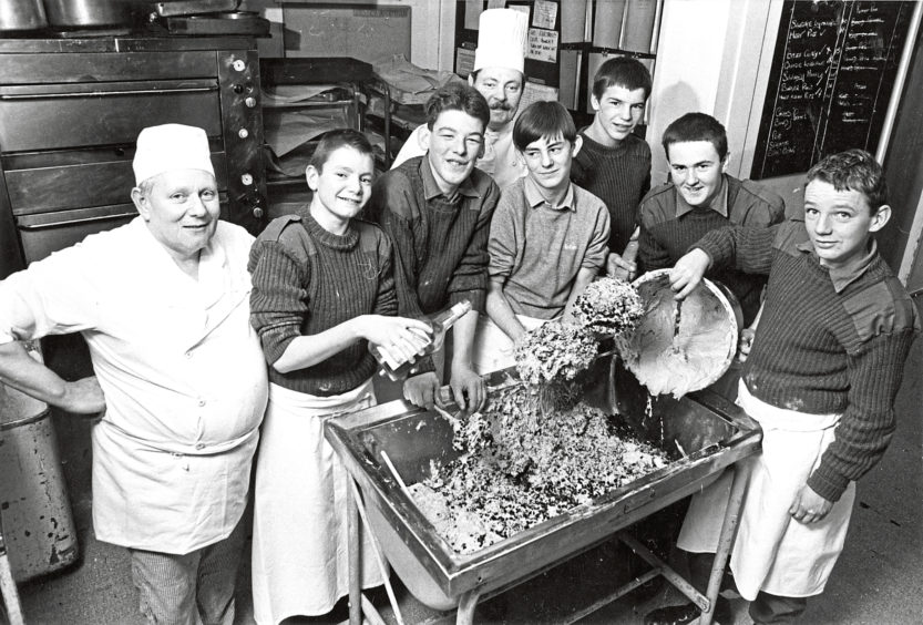 1980: Staff Quarter Master Sgt Ray McAlinden, centre, is helped to bake a 200lb Christmas cake for the Evening Express senior citizens film show