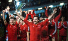 Aberdeen captain Willie Miller holds aloft the European Cup Winners' Cup, wearing the iconic shirt.