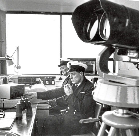 1970: Keeping the coast safe and manning the equipment at the Aberdeen Rescue headquarters at Gregness are Station Officer R Rainford, nearest the camera, and coastguard Charles Thompson. Their equipment included the huge German binoculars in the foreground, at one time the eyes of the officer on duty to keep a constant watch on the sea.