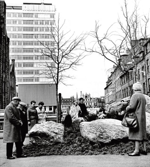 1970: Passers-by check out an 'instant garden' that council workers put up in one night on the former site of the city's tourist information bureau