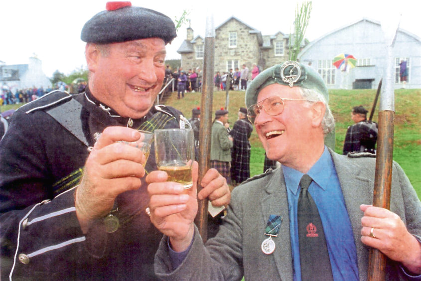 Doric legend Robbie Shepherd shares a dram with Bill Gardiner of Stonehaven at the Lonach Hall.