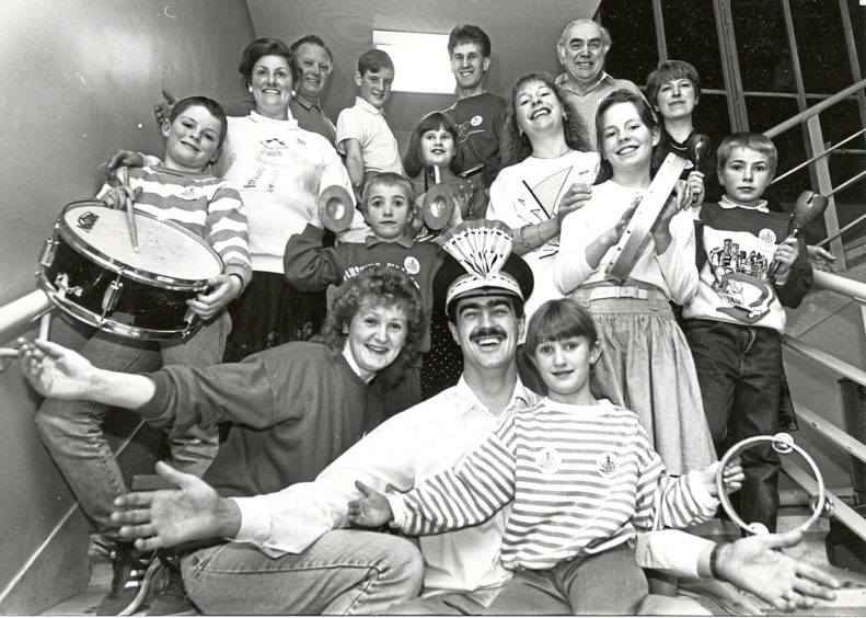 1990: Tony Burgess, who plays the lead in The Music Man to be held at His Majesty's Theatre from tomorrow until Saturday, gets into the spirit of things with his wife Pamela and seven year old daughter Lisa who are also in the show. The five other families taking part in the Lyric Music Society's latest show, gather round.