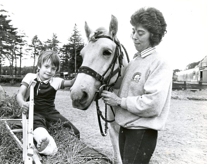 1990: Five year old Jeremy Harris, Aberdeen, who broke his leg on Sunday at an Inverurie play park, gives Fergus a playful pat under the watchful eye of Mrs Sue Crawford at Hayfield Riding Centre, Aberdeen.