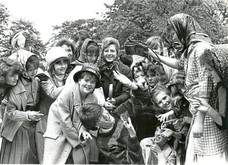 1988: Hazlehead Academy's street theatre group go through their paces at Hazlehead Park in preparation for their performances of Wifies. Surrounded by wifies here is Lee Mundie (centre), who is taking a hammering from the handbag held by beverley Menmuir.