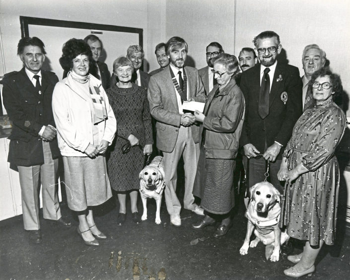 1984: £1000 boost was put into the coffers of the Guide Dogs for the Blind last night, thanks to the efforts of schoolchildren in Grampian who raised cash in a sponsored football competition. More than £3000 was raised during the event which is organised annually by Bucksburn and District Round Table. Aberdeen branch chairman Mrs Sally Leiper (centre) accepts the £1000 cheque from Buchan Tablers chairman Mr John Leheny. The presentation took place after the branch annual meeting. Also pictured are members of the Round Table and commitee members of the Guide Dogs for the Blind branch including Miss Isobel Mundie (left) and her dog, Unity, and (right) Mr Jack Smith with Victor.