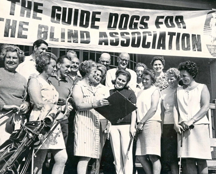 1970: The golf course at Hazlehead was the scene of a hard hitting bid to raise money to buy guide dogs for the blind. In our picture, Mrs D. M. Godsman shows competitors their starting times at the start of the mixed foursomes, in aid of Guide Dogs for the Blind Association, Aberdeen branch. Well known Aberdeen player Mrs Joan Rennie (dark sweater) looks on."