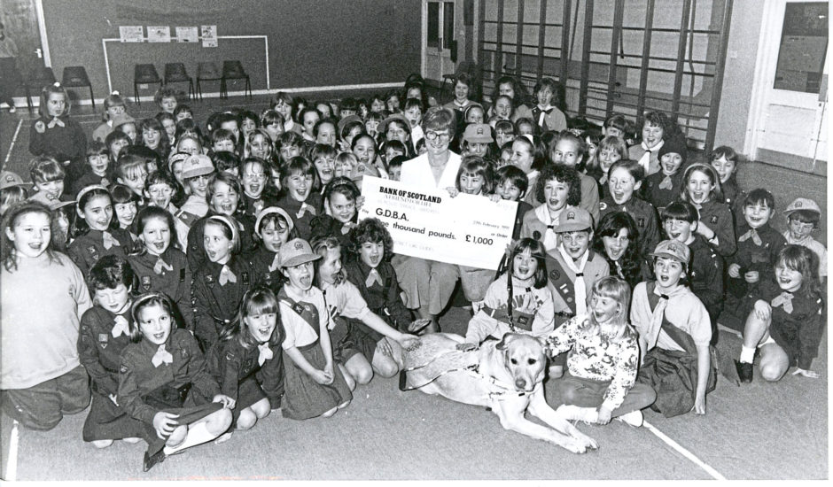 1991: Guides and Brownies of the Parkway District of Aberdeen Guides had a fundraising drive during which they raised £1,000 for the Guide Dogs for the Blind Association. All the fundraisers gathered in Westfield Primary School, Bridge of Don, to present the cheque to Mrs Nessie Fraser and her guide dog, Norman.