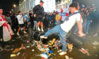 English fans kick and stand on a litter bin in Piccadilly Circus, London, after Italy beat England on penalties to win the UEFA Euro 2020 Final. Picture date: Monday July 12, 2021.