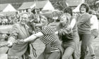 1982 - Helping hand during the Ballater Games tug o’ war from games committee secretary Rupert MacNamee, left, for the Air Call Communications team from Tullos, Aberdeen, headed by secretary Valerie Boyko