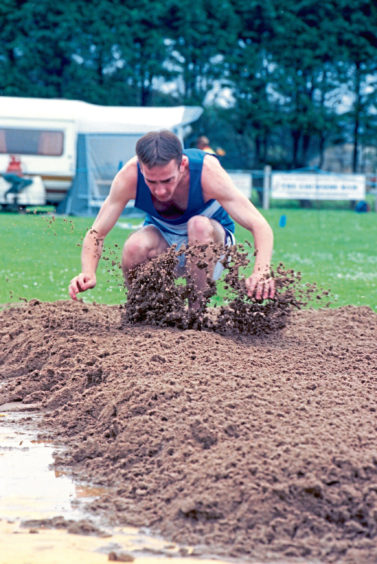 1998 - A long jump competitor lands in the sand at the 1998 Stonehaven Highland Games
