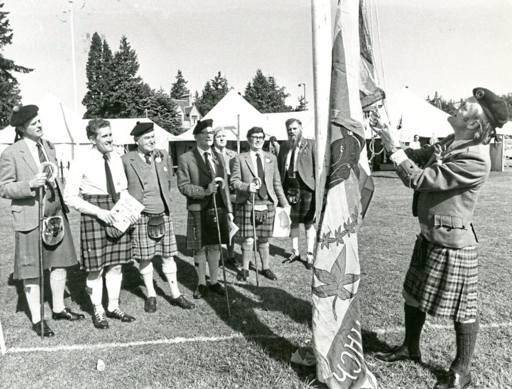1980 - Alistair Lilburn, chairman of the Aboyne Games, raises the standard at the games, watched by officials