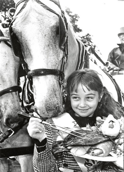 1990 - Jan the horse gets a noseful as ten-year-old  Festival Princess Danielle Maloney opens  the 7th Aberdeen Fish Festival with a fish  breakfast at the Caledonian Hotel