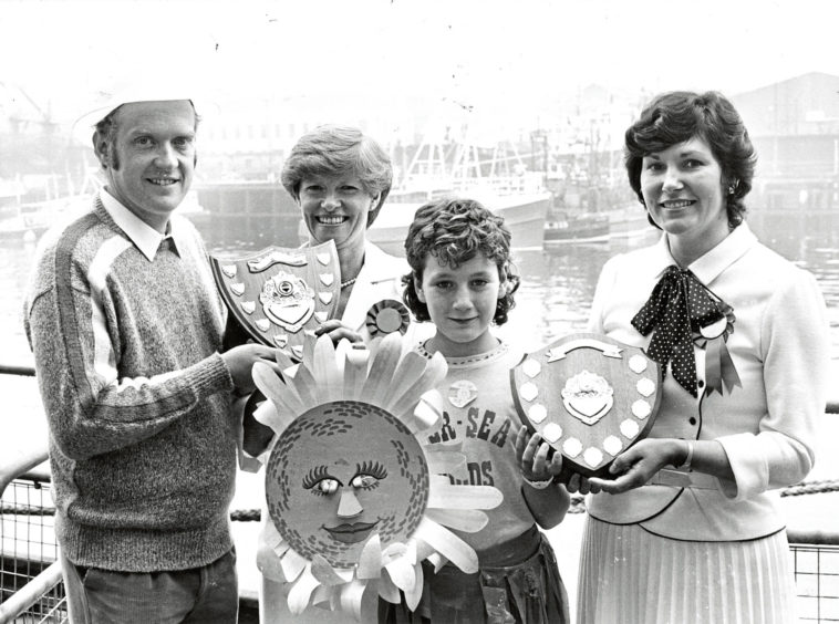1985 - Lynne Taylor, 10, accepts the Press and Journal Shield  for the best fish display, on behalf of NorSea Foods, from  Elizabeth Kennedy, while William Merson of Merson and  Gerry accepts the Shell UK Shield for the best overall  display from Jennifer Walker