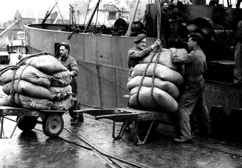 Military personnel working in the habour during a dock workers strike, 25th May 1945
