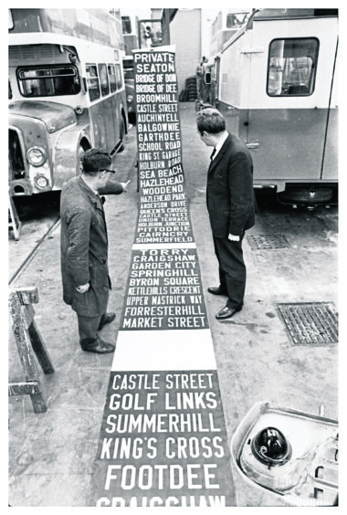 1969: In the paint shop at King Street Mr T. Ferguson and Mr A. Strachan, the rolling stock engineer, examine a destination screen used on the Corporation buses. The screens are about 60ft. long and have space for about 120 place names.