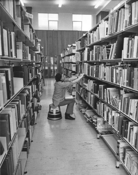 1970: Student searching for a book in the library, College of Education, Hilton.