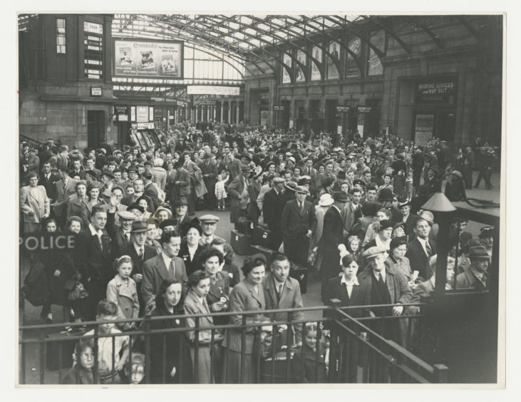 1950: Aberdonians queuing up at Aberdeen Joint Station during the July trades holiday in 1950. The covered concourse is packed with families waiting to get away.