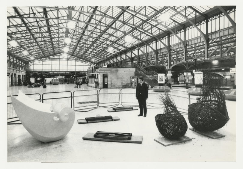 1988: ScotRail manager Nigel Wunsch cast an appraising eye over an exhibition of Scottish sculptures at Aberdeen Station. Organised by the Scottish Sculpture Trust and subsidised by the Scottish Arts Council the show comprises three pieces: from left, Fluted Wave by Sybille van Helem; Orkney Trine by Frances Pelly; and Tree Pods by Valerie Pragnell.