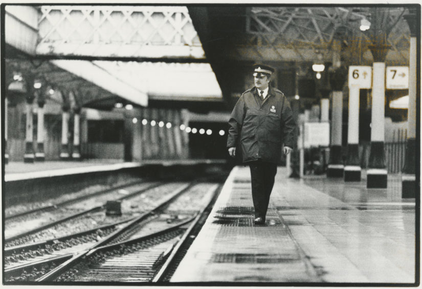 1993: A policeman patrols a deserted Aberdeen railway station platform.