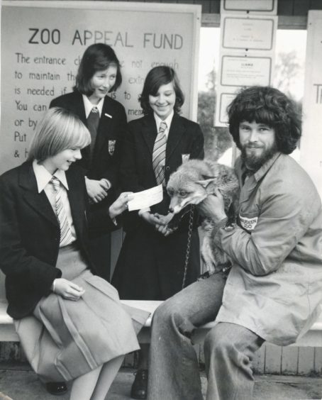1977: Zoo keeper John Buchan and Foxy accept the £80 cheque from (seated) Susan Hodge (13) and (back left) Jill Dawson (13) and Debbie Megginson (13).