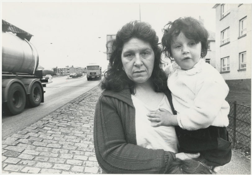 Jeanie O’Halloran, of Logie Avenue, Aberdeen, stands beside North Anderson Drive with daughter Janey at the exact spot where the accident happened [5 April 1990], and also where little Janey was knocked down.  6 April 1990.