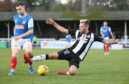 Brian Cameron slides in to make a challenge for Elgin