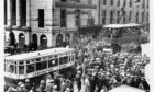 1928: A bus and a tram come to a halt on Union Street as people crane to see the Prince of Wales on a visit.